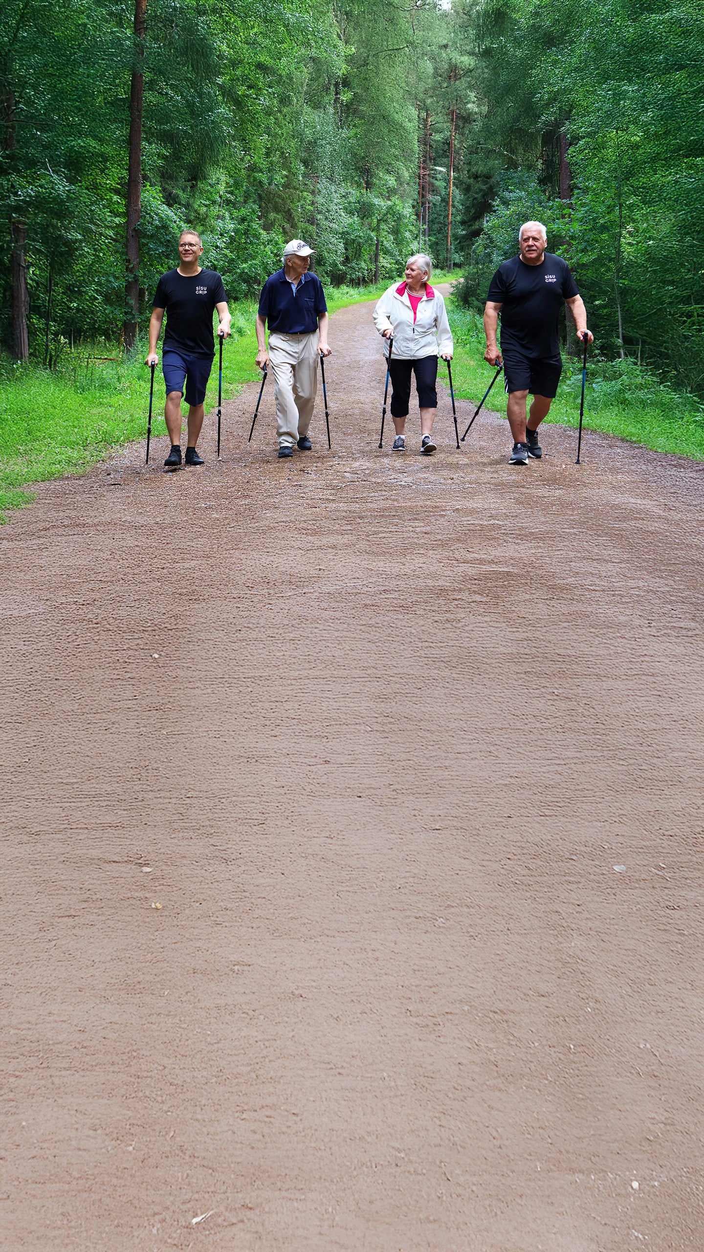 Neljä kävelijää käyttää Sisu Grip sauvoja metsäpolulla